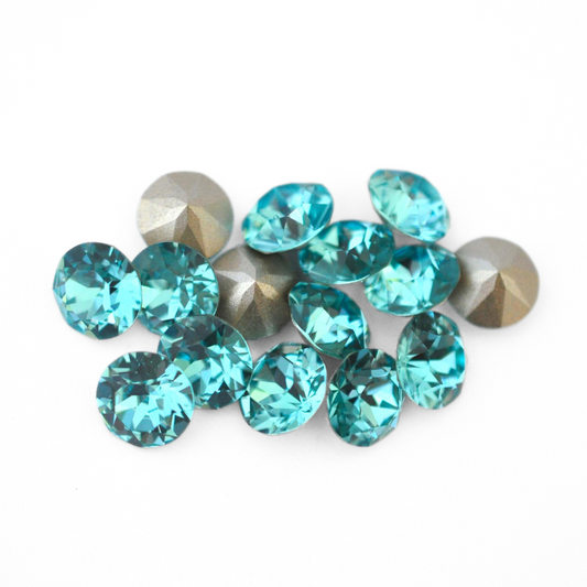 Round faceted Austrian crystal rhinestones in the color Light Turquoise displayed on a white background