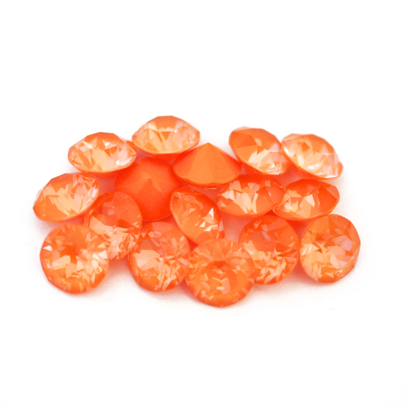 Round faceted Austrian crystal rhinestones in the color Mango Ignite displayed on a white background.