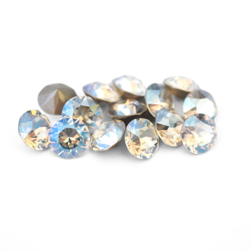 Round faceted Austrian crystal rhinestones in the color Moonlight displayed on a white background.