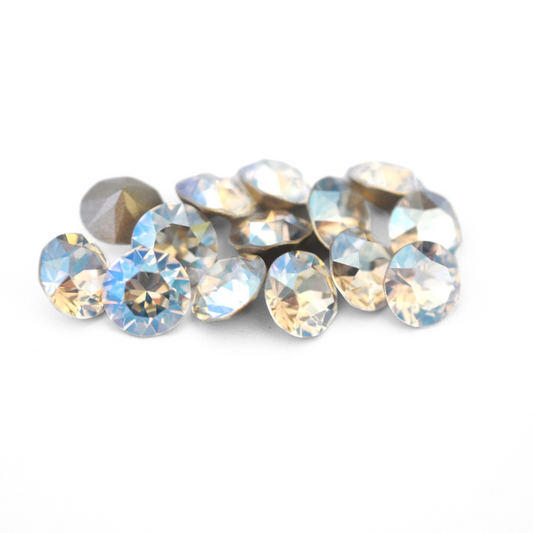 Round faceted Austrian crystal rhinestones in the color Moonlight displayed on a white background.