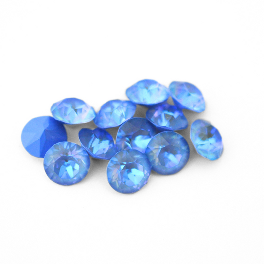 Round faceted Austrian crystal rhinestones in the color Ocean Delite displayed on a white background