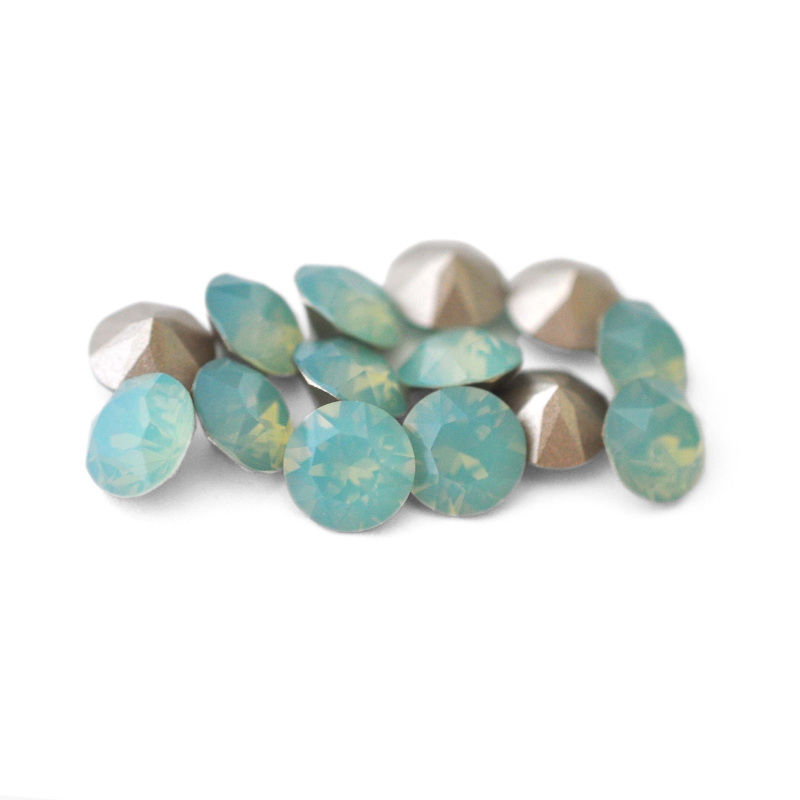 Round faceted Austrian crystal rhinestones in the color Pacific Opal displayed on a white background.