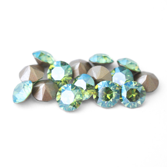 Round faceted Austrian crystal rhinestones in the color Peridot Moonlight displayed on a white background.