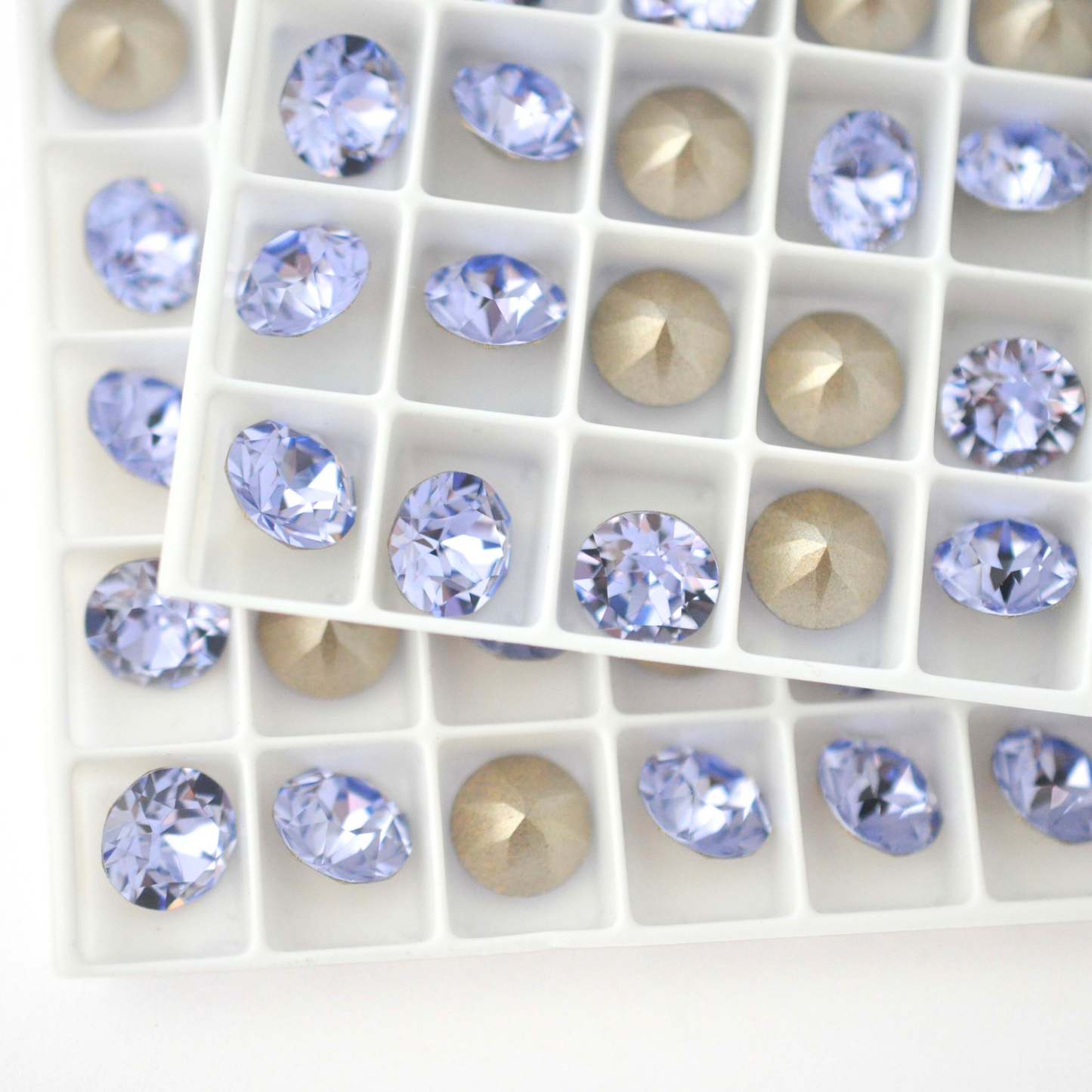 Round faceted Austrian crystal rhinestones in the color Provence Lavender in a tray.