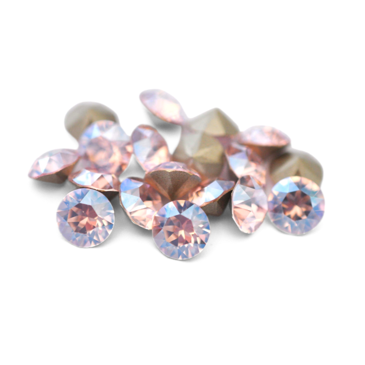 Round faceted Austrian crystal rhinestones in the color Rosaline Moonlight displayed on a white background.