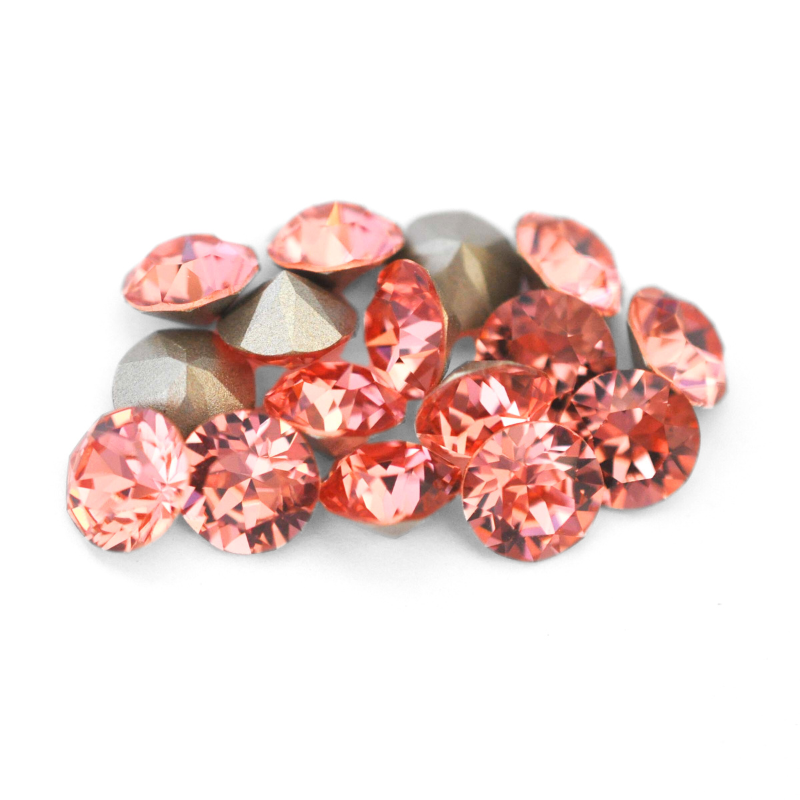 Round faceted Austrian crystal rhinestones in the color Rose Peach displayed on a white background.