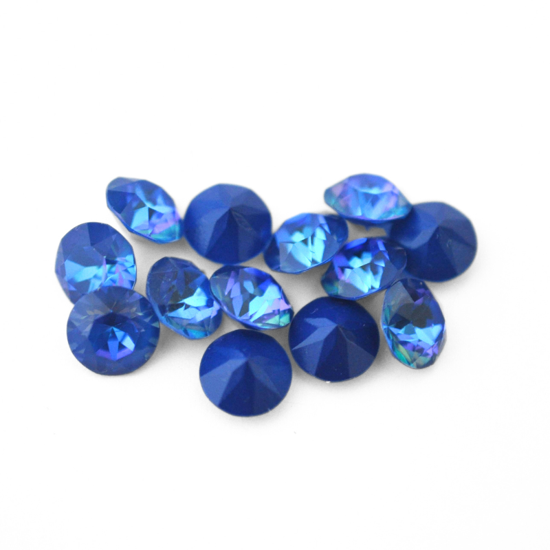 Round faceted Austrian crystal rhinestones in the color Royal Blue Delite displayed on a white background
