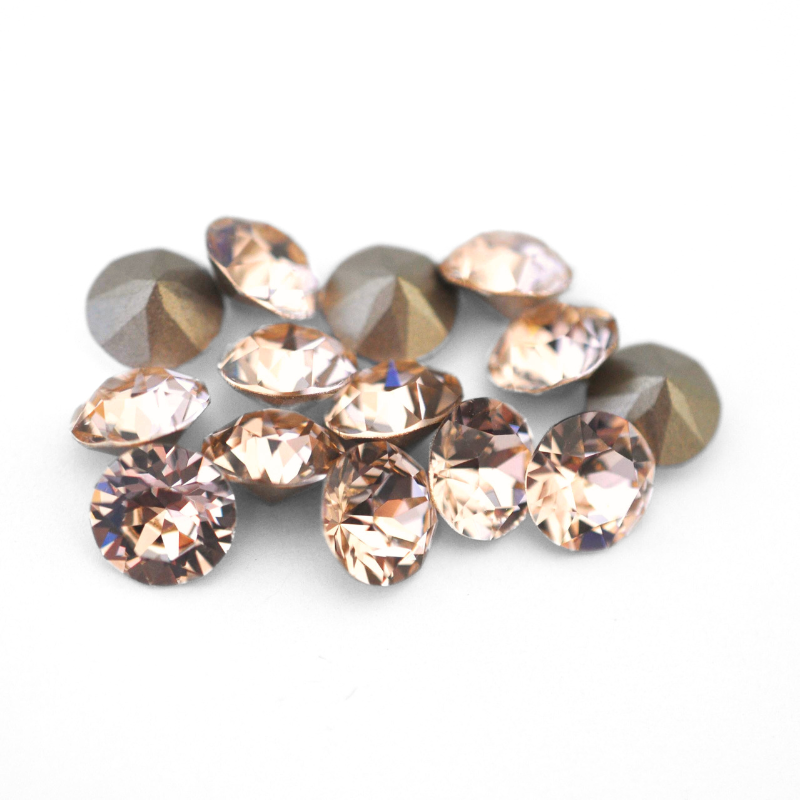 Round faceted Austrian crystal rhinestones in the color Silk displayed on a white background.