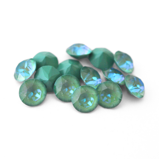 Round faceted Austrian crystal rhinestones in the color Silky Sage Delite displayed on a white background.