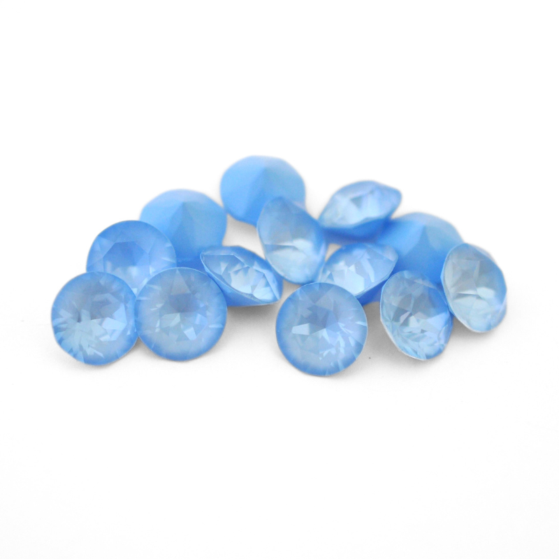 Round faceted Austrian crystal rhinestones in the color Sky Ignite displayed on a white background.