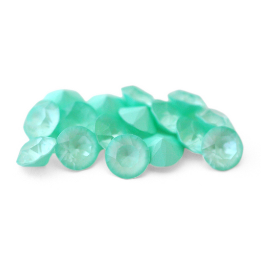 Round faceted Austrian crystal rhinestones in the color Soft Mint Ignite displayed on a white background.