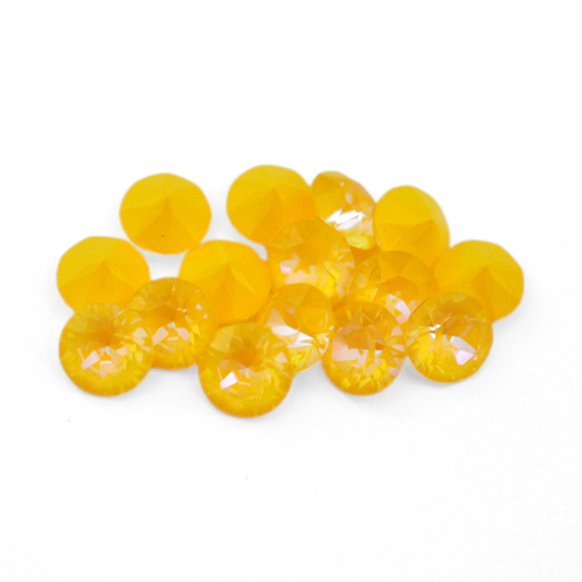 Round faceted Austrian crystal rhinestones in the color Sunshine Delite displayed on a white background.