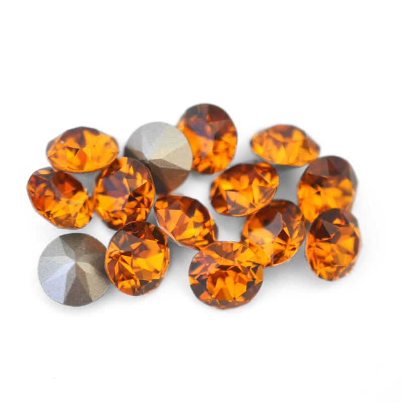 Round faceted Austrian crystal rhinestones in the color Topaz displayed on a white background.