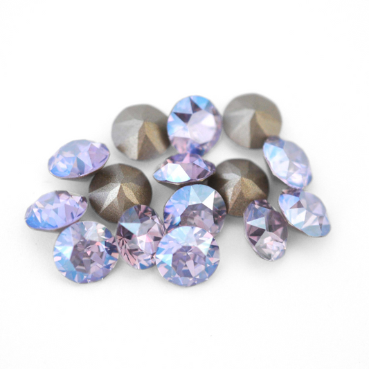 Round faceted Austrian crystal rhinestones in the color Violet Moonlight displayed on a white background.