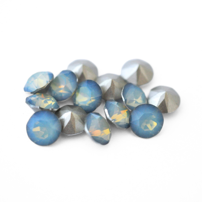 Round faceted Austrian crystal rhinestones in the color White Opal Sky Blue displayed on a white background.
