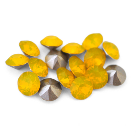 Round faceted Austrian crystal rhinestones in the color Yellow Opal displayed on a white background.