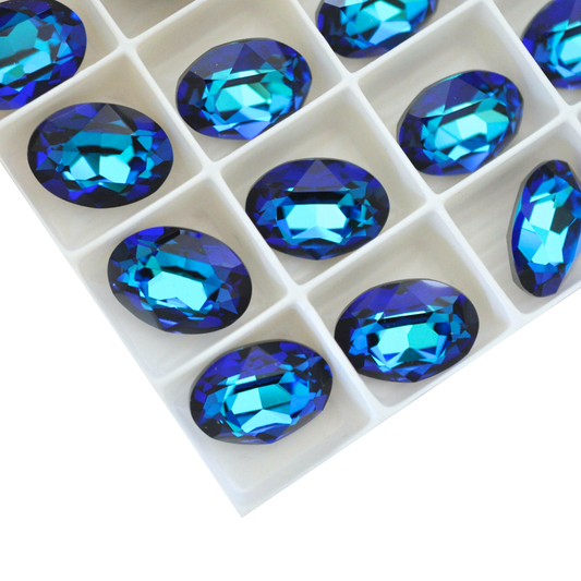 Oval shape faceted Austrian crystal rhinestones in the color Bermuda Blue displayed on a white background.