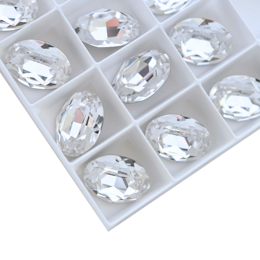 Oval shape faceted Austrian crystal rhinestones in the color Crystal displayed on a white background. 