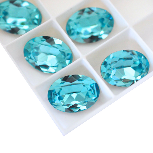 Oval shape faceted Austrian crystal rhinestones in the color Light Turquoise displayed on a white background.