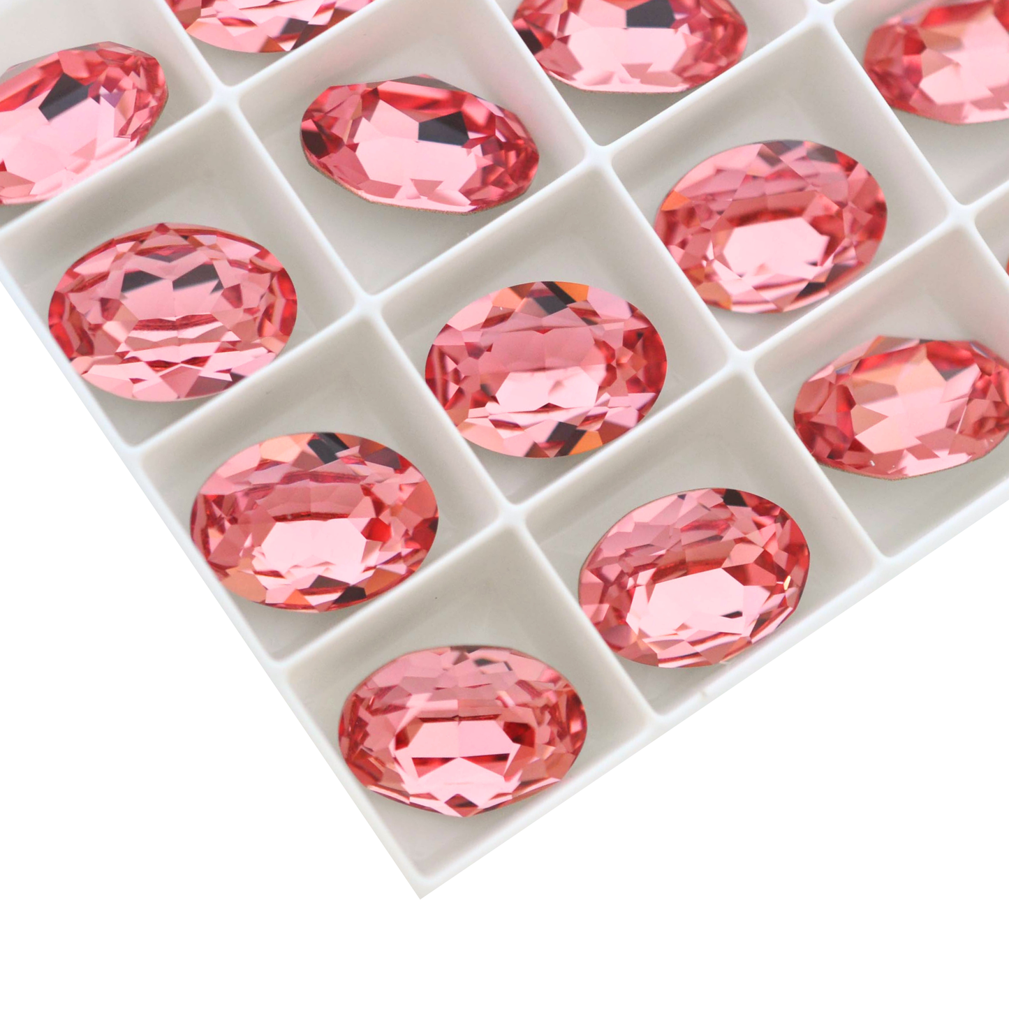 Oval shape faceted Austrian crystal rhinestones in the color Rose Peach displayed on a white background.