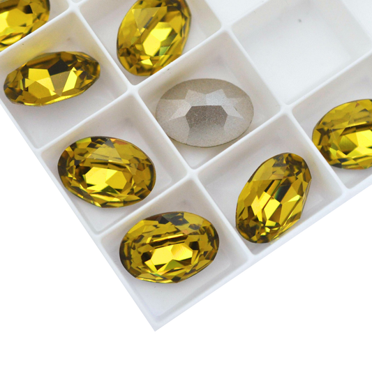 Oval shape faceted Austrian crystal rhinestones in the color Vintage Lime displayed on a white background.