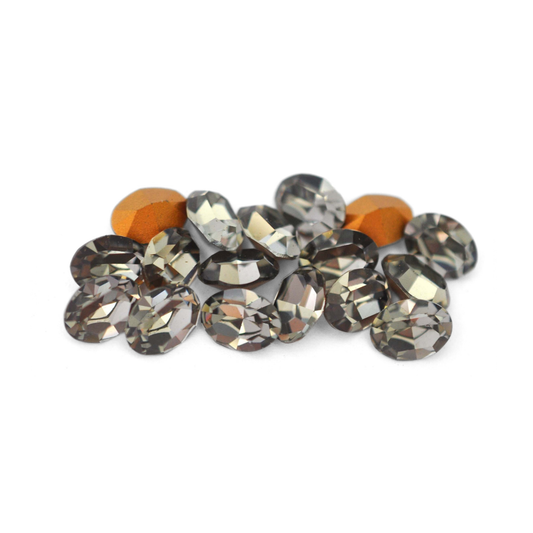 Oval shaped faceted Austrian crystal rhinestones in the color Black Diamond displayed on a white background. 