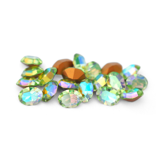 Oval shaped faceted Austrian crystal rhinestones in the color Chrysolite AB displayed on a white background. 