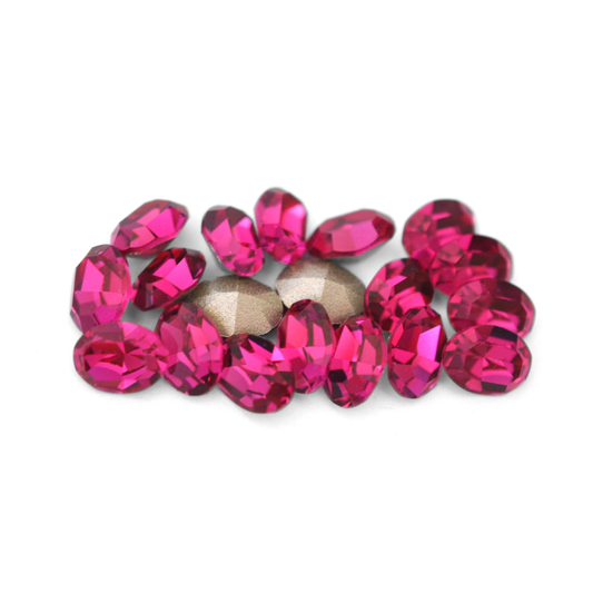 Oval shaped faceted Austrian crystal rhinestones in the color Fuchsia displayed on a white background. 