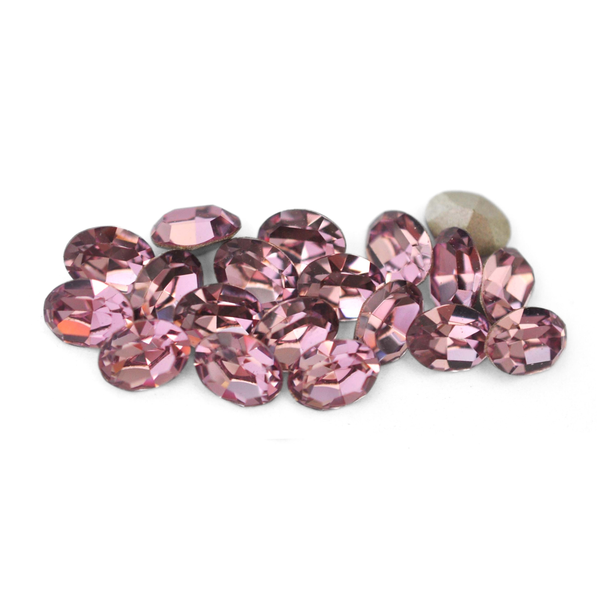 Oval shaped faceted Austrian crystal rhinestones in the color Light Amethyst displayed on a white background. 