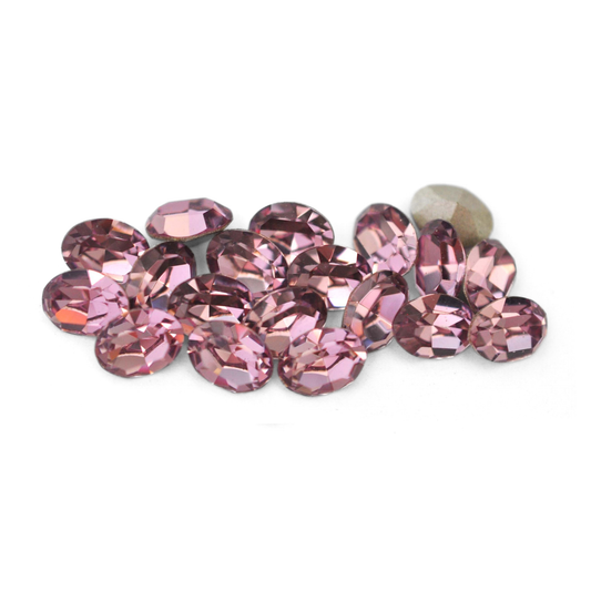 Oval shaped faceted Austrian crystal rhinestones in the color Light Amethyst displayed on a white background. 