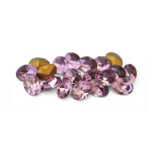 Oval shaped faceted Austrian crystal rhinestones in the color Light Amethyst displayed on a white background. 
