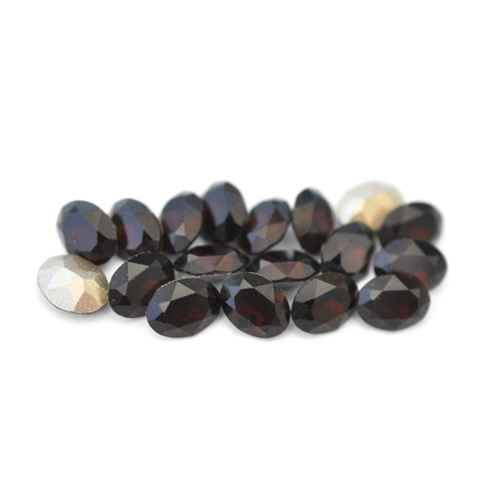 Oval shaped faceted Austrian crystal rhinestones in the color Mocca displayed on a white background. 