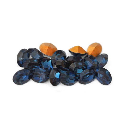 Oval shaped faceted Austrian crystal rhinestones in the color Montana displayed on a white background. 