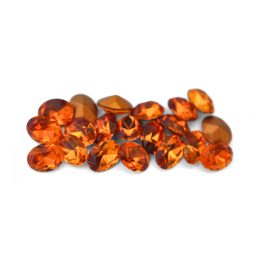 Oval shaped faceted Austrian crystal rhinestones in the color Topaz displayed on a white background. 