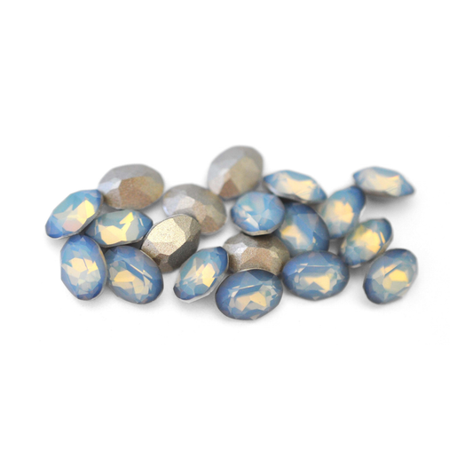 Oval shaped faceted Austrian crystal rhinestones in the color White Opal Star Shine displayed on a white background. 
