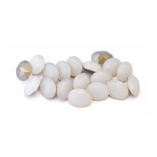 Oval shaped faceted Austrian crystal rhinestones in the color White Alabaster displayed on a white background. 