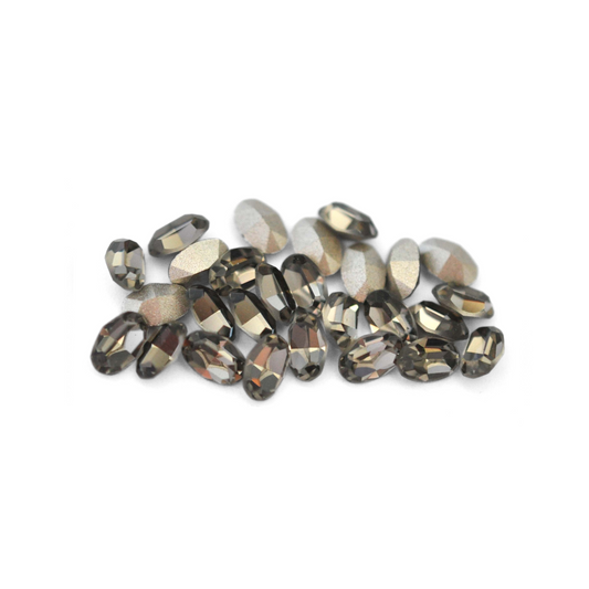 Oval shaped faceted Austrian crystal rhinestones in the color Black Diamond displayed on a white background. 