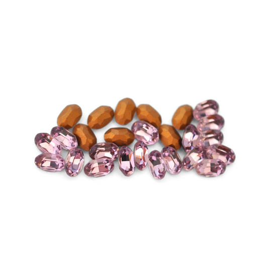 Oval shaped faceted Austrian crystal rhinestones in the color Light Amethyst displayed on a white background. 