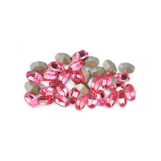 Oval shaped faceted Austrian crystal rhinestones in the color Light Rose displayed on a white background. 