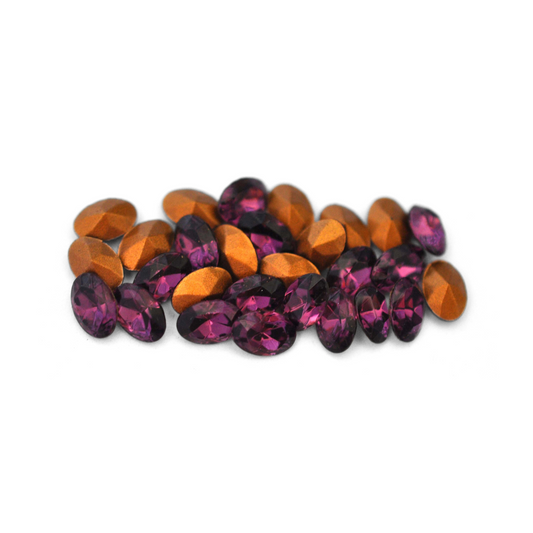 Oval shaped faceted Austrian crystal rhinestones in the color Amethyst displayed on a white background. 