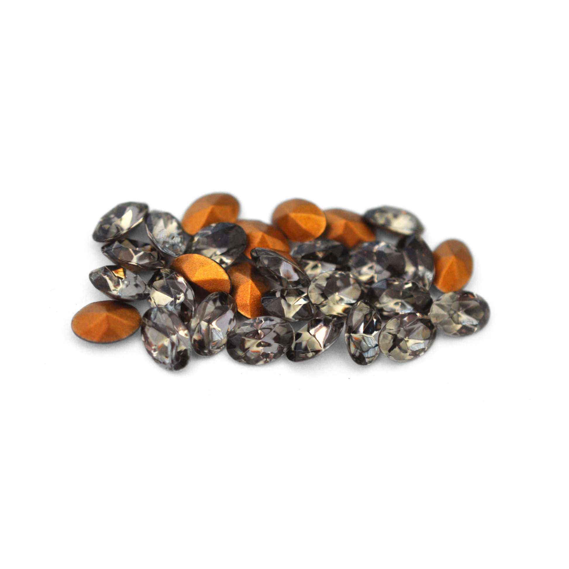 Oval shaped faceted Austrian crystal rhinestones in the color Black Diamond displayed on a white background. 