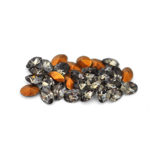 Oval shaped faceted Austrian crystal rhinestones in the color Black Diamond displayed on a white background. 