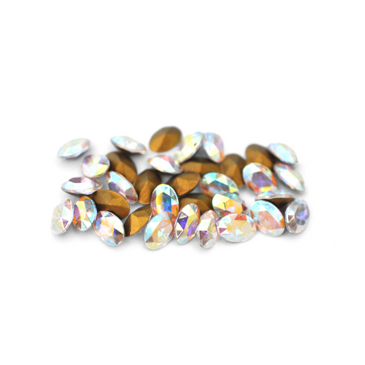 Oval shaped faceted Austrian crystal rhinestones in the color Crystal AB displayed on a white background. 