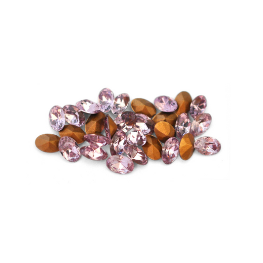 Oval shaped faceted Austrian crystal rhinestones in the color Light Amethyst displayed on a white background. 