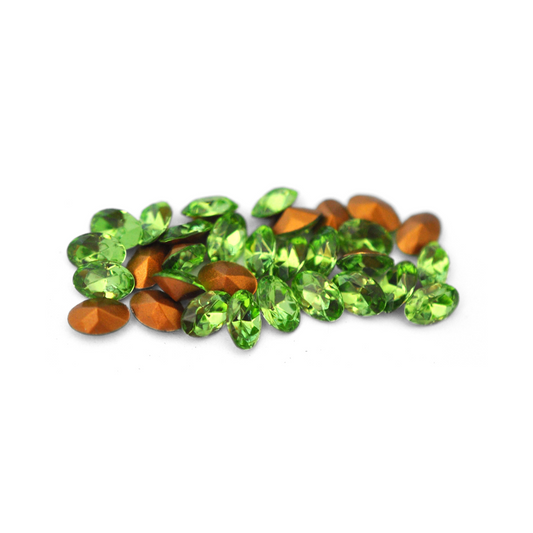 Oval shaped faceted Austrian crystal rhinestones in the color Peridot displayed on a white background. 