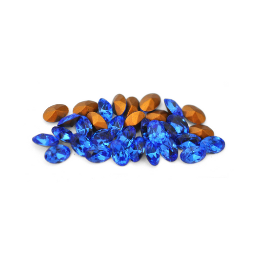 Oval shaped faceted Austrian crystal rhinestones in the color Sapphire displayed on a white background. 