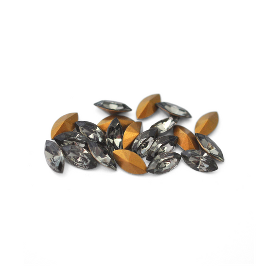 Navette shaped faceted Austrian crystal rhinestones in the color Black Diamond displayed on a white background. 