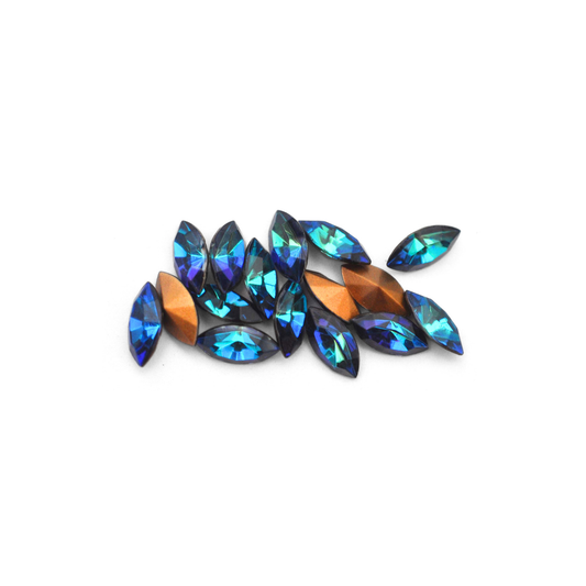 Navette shaped faceted Austrian crystal rhinestones in the color Heliotrope displayed on a white background.