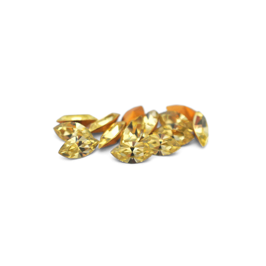 Navette shaped faceted Austrian crystal rhinestones in the color Jonquil displayed on a white background.