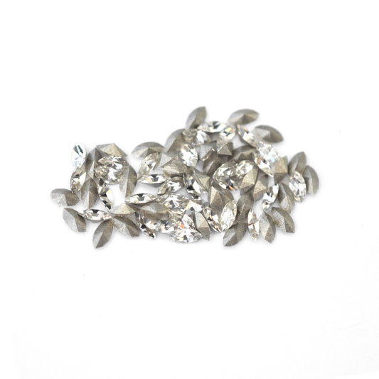 Navette shaped faceted Austrian crystal rhinestones in the color Crystal displayed on a white background.